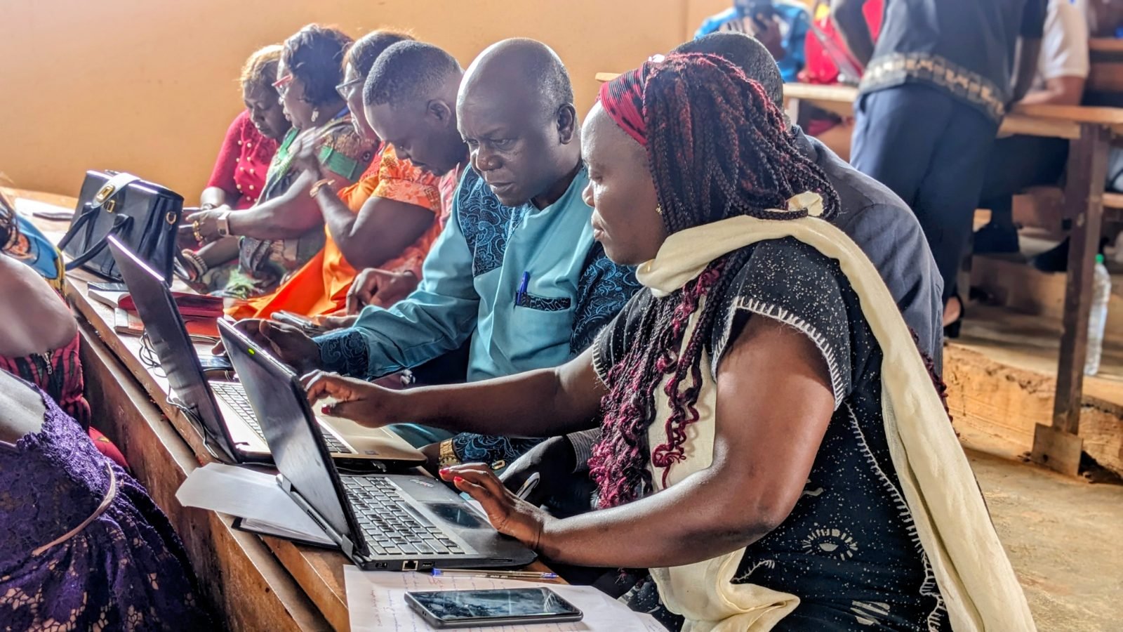 Des participants, assis côte à côte, travaillent sur leurs ordinateurs portables.