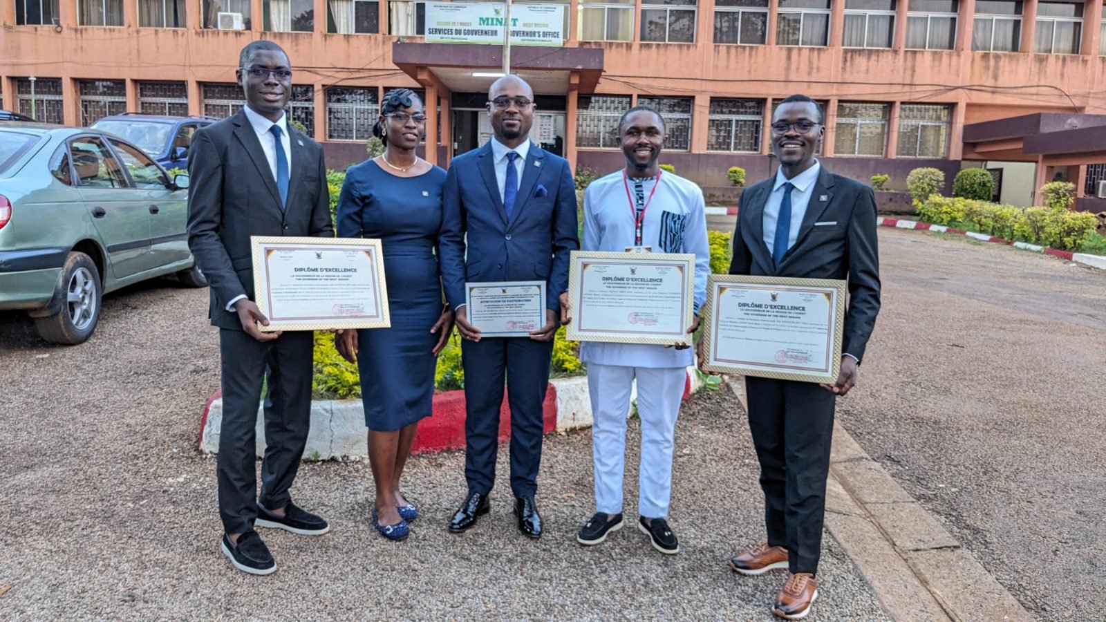 L’équipe de ASK Institute, rejointe par un autre participant, présente des diplômes devant les services du Gouverneur de la Région de l’Ouest.